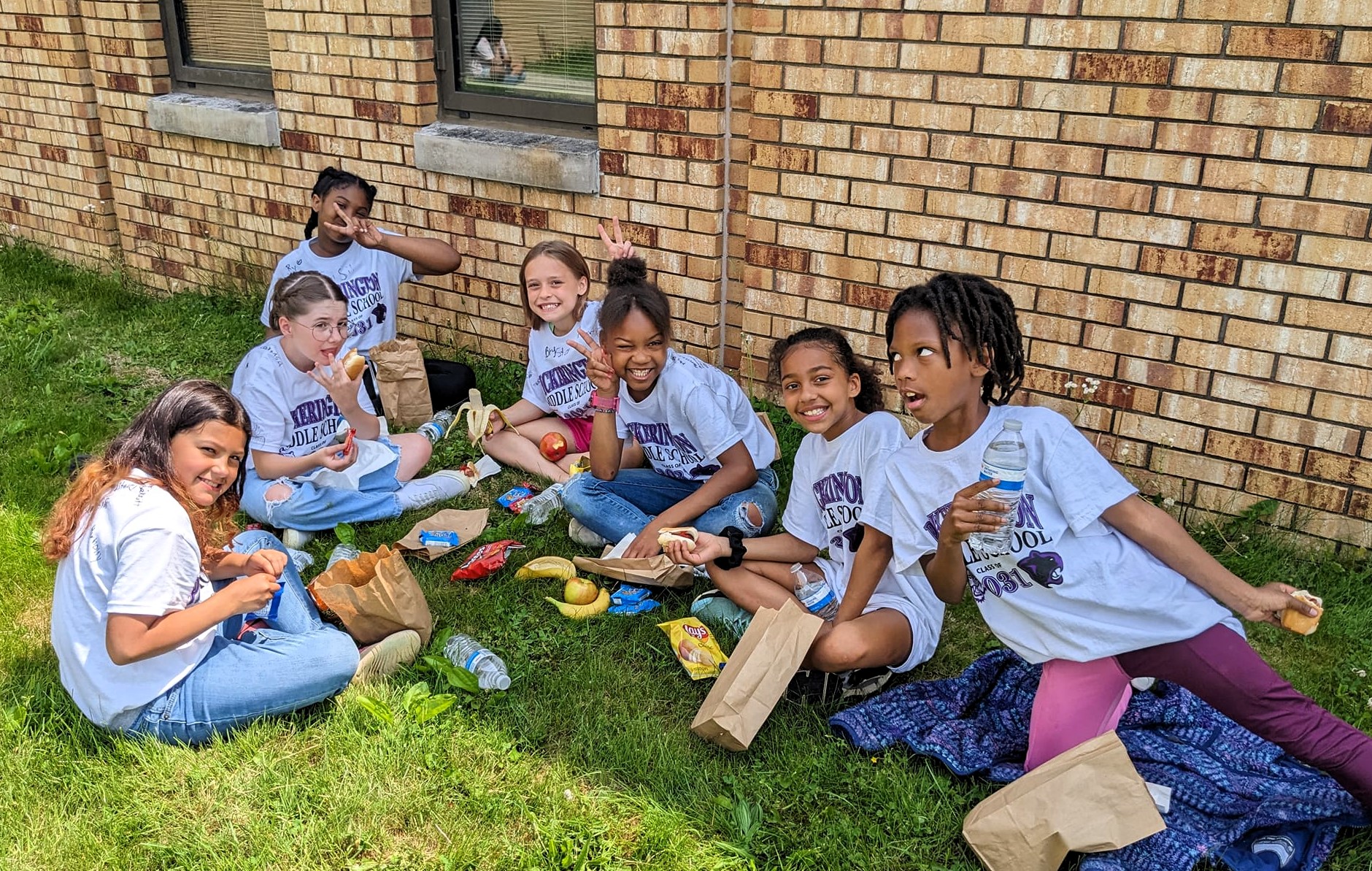 Fairfield Elementary students eating lunch outside on a sunny day.