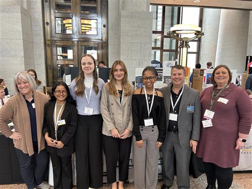  students in a group shot with displays