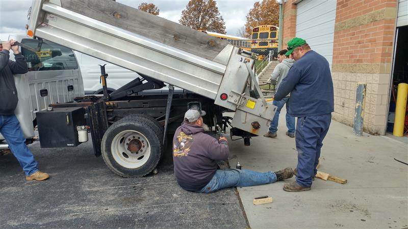 Kyle Bigham and Chuck McDaniel fixing the salt spreader on the dump truck