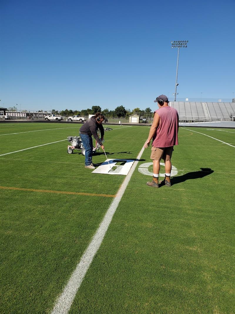 Stenciling numbers on the field at Panther Stadium